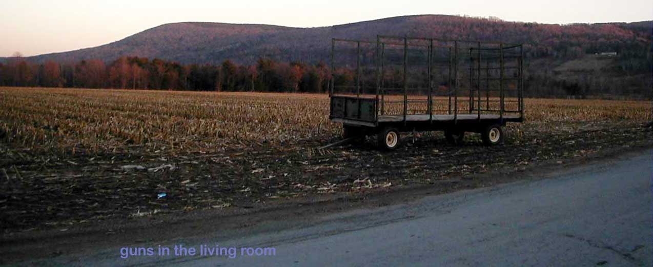 a barren field in fall with empty hay wagon